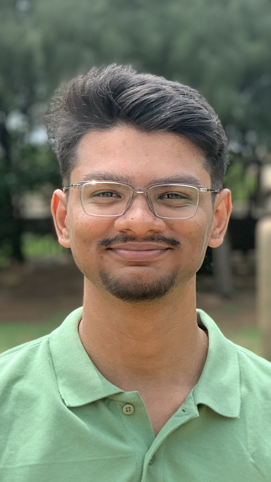 Sriram M. outdoors, smiling at the camera.